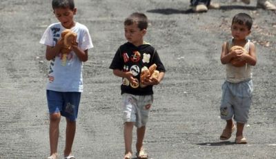 Syrian refugee children carry loaves of bread at a refugee camp in the Turkish border town of Yayladagi, in Hatay province June 27, 2011. REUTERS/Osman Orsal (TURKEY - Tags: POLITICS CIVIL UNREST)